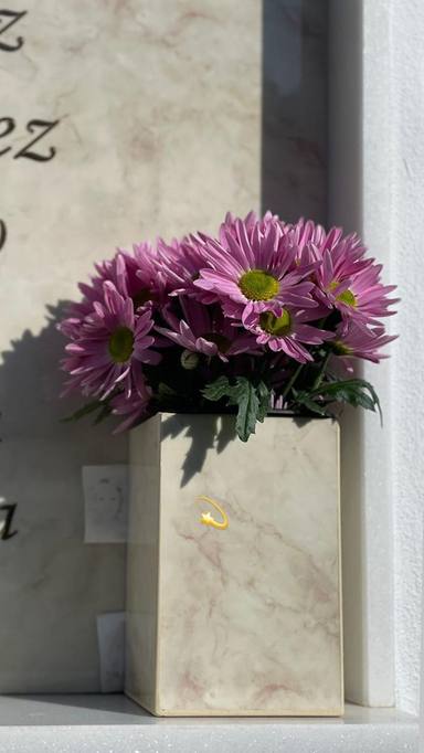 Irene Rosales muestra las flores que ha colocado en la tumba de su madre en el segundo aniversario